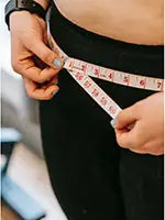 woman measuring waist with tailors tape